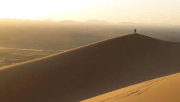 Person on top of sand dune