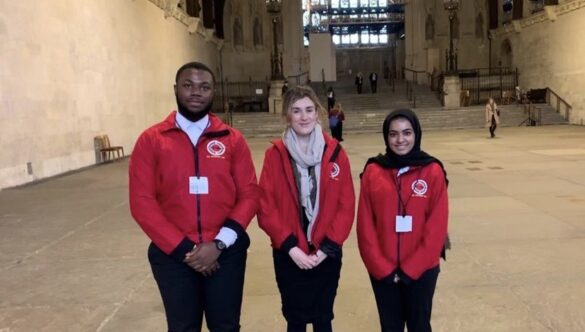 Three volunteer mentors standing outside of Parliament